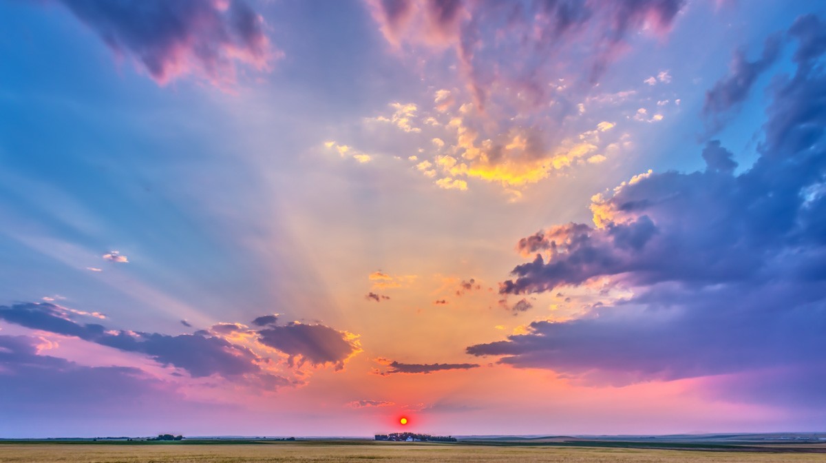 Red sun setting over a prairie landscape